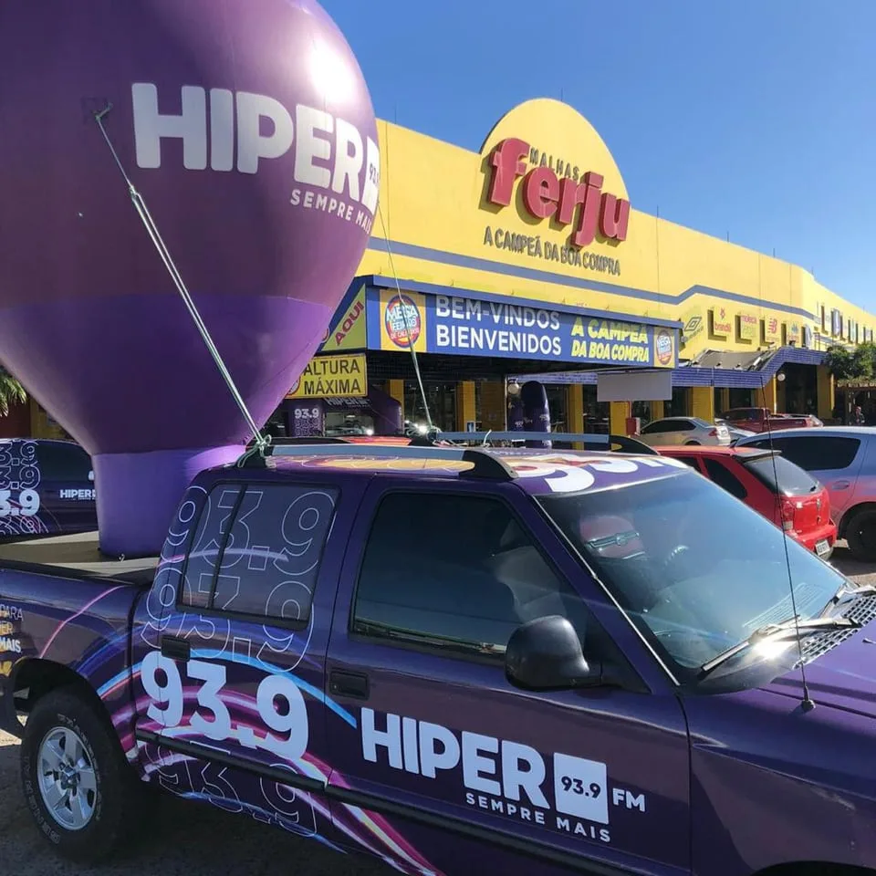 Carro da Hiper 93.9 e balão em frente a uma loja